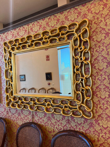 Espejo dorado con forma de cadena.