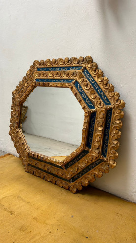 Espejo octagonal tallado en madera y decorado con cristales azules pintados a mano.