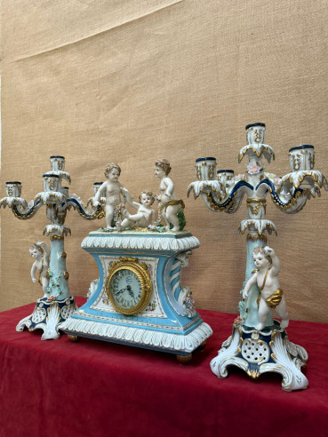 Pareja de candelabros en porcelana con reloj de sobremesa.